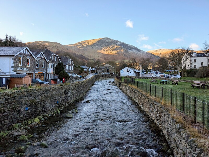 The bridge in the village looking up towards Birkhouse Moor and beyond - © Copyright 2025 Peter Burlingham, Days In The Lakes
