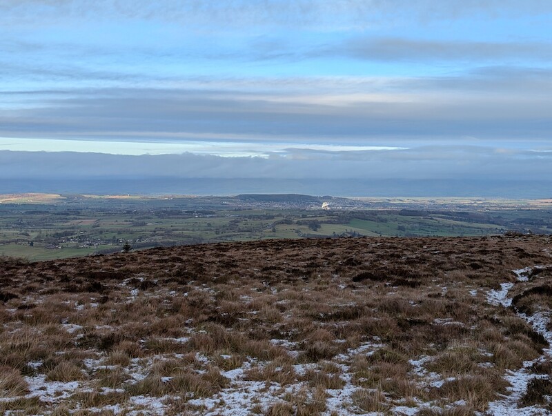 Looking towards Penrith with the wooded Beacon Hill in the centre and the North Pennines blending a little into the clouds - © Copyright 2025 Peter Burlingham, Days In The Lakes