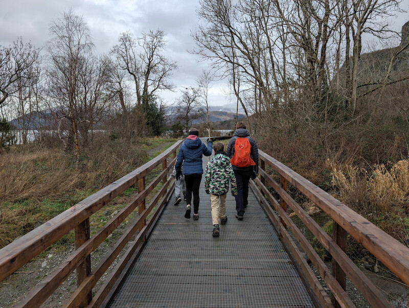 Mum, Millie, Sam and James on the boardwalk by the lake - Millie also has a stick! - © Copyright 2025 Peter Burlingham, Days In The Lakes