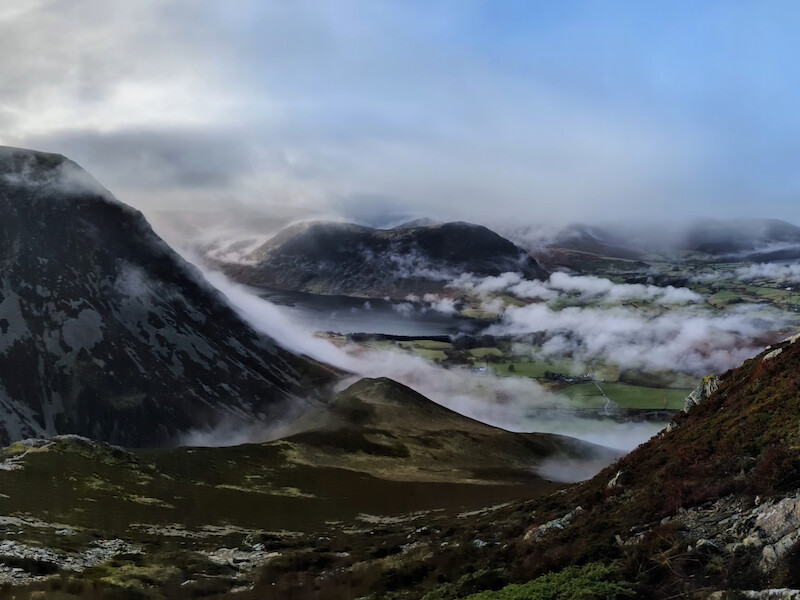 A stunning view across Crummock Water to Mellbreak on the far side - the cloud rolling down Grasmoor on the left of the photo - © Copyright 2025 Peter Burlingham, Days In The Lakes