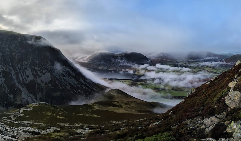A stunning view across Crummock Water to Mellbreak on the far side - the cloud rolling down Grasmoor on the left of the photo - © Copyright 2025 Peter Burlingham, Days In The Lakes